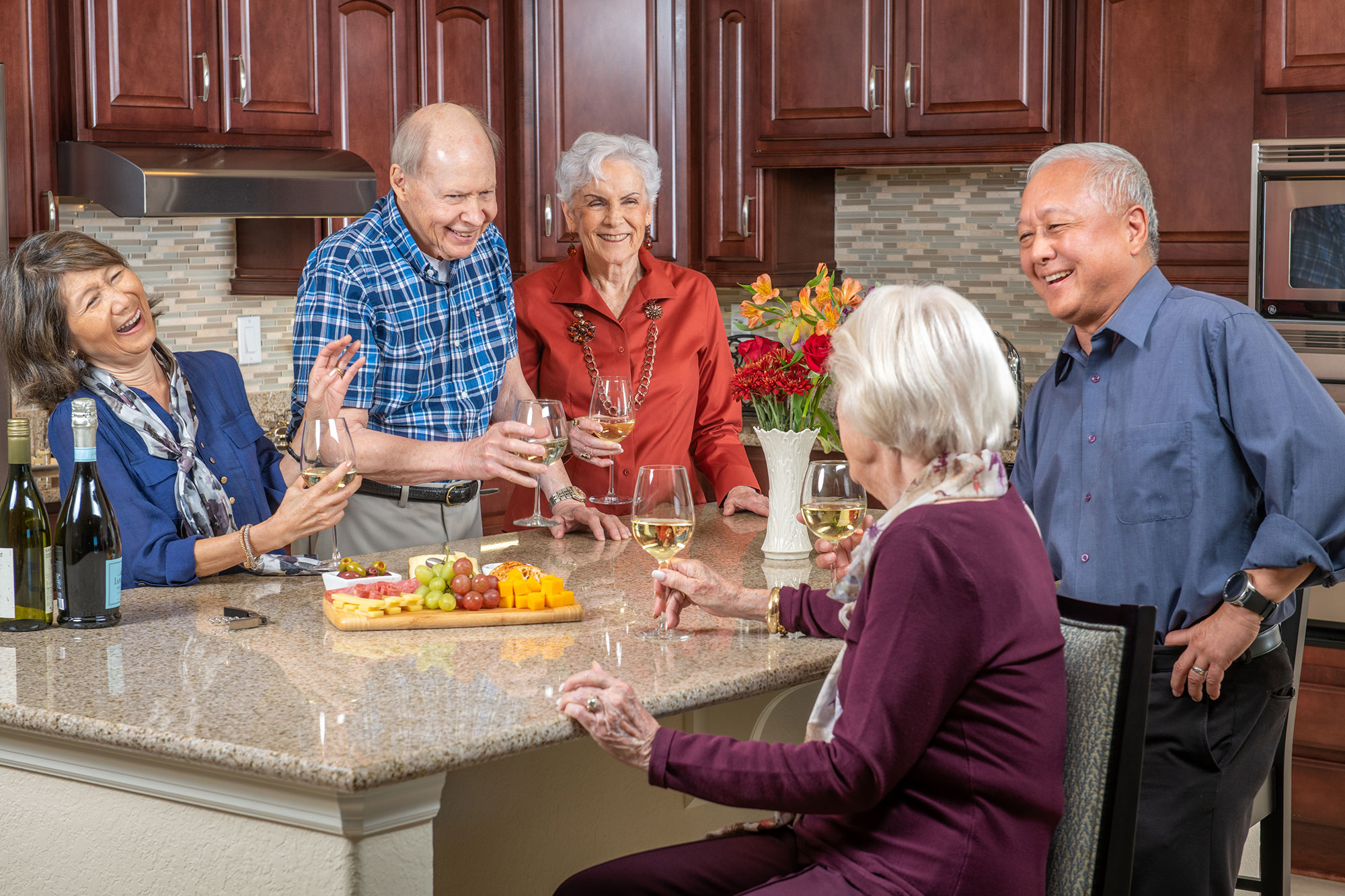 Group of residents gathered around a kitchen island at The Terraces at Bonita Springs